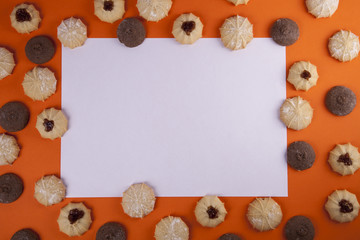 White paper card and cookies on orange background