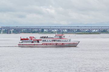 Walking river boat on the background of the bridge on the Volga River