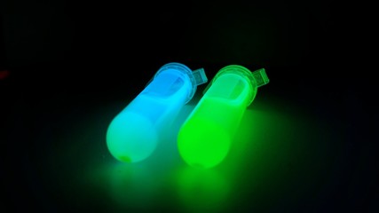 Plastic tubes with quantum dots of perovskite nanocrystals glowing with blue and green luminescence...