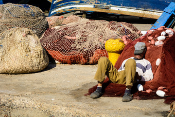 A fisherman sleeping on the harbor in Essaouira, Morocco