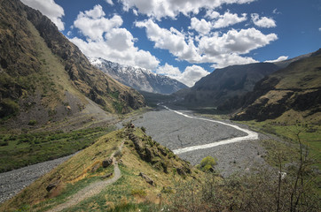 Scenic view on Caucasus mountains in Georgia. A small river flows down the gorge