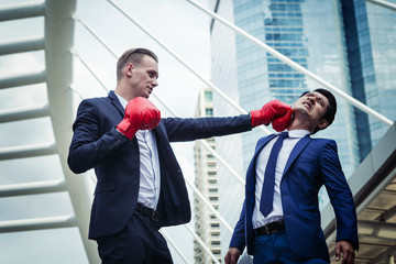 two business man fighting together use boxing mitts, competitor concept