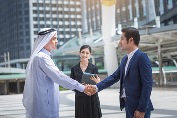 business deal between asian and Arabs peoples working outdoor