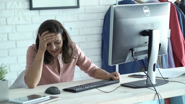 Tired businesswoman with PC computer falling asleep on table in office
