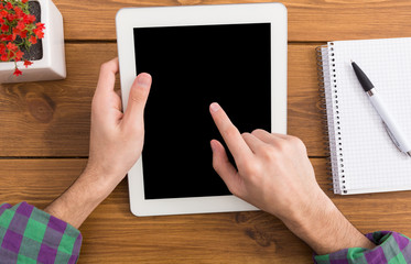 Male using digital tablet, close up, top view,