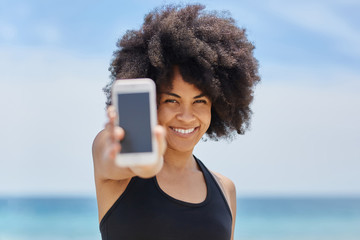 Happy afro american girl holding smartphone