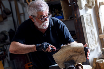 Senior sculptor working on his sculpture in his workshop.