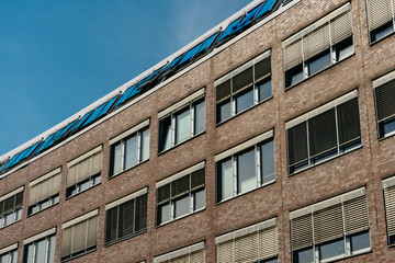 Fototapeta premium brick office building with blue blinds on the rooftop