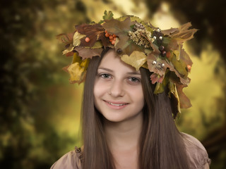 beautiful wreath of autumn leaves on the head of a young girl