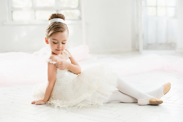 The little balerina in white tutu in class at the ballet school © master1305