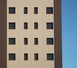 Facade with two brown shades of a residential building with gray shutters