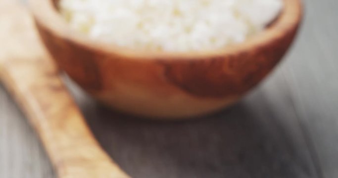 fresh cottage cheese in a wood bowl on a wooden table