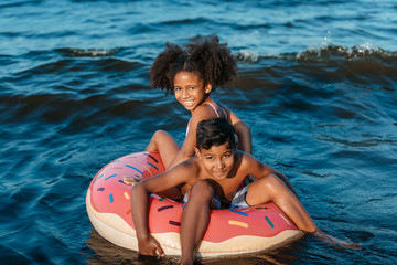 Obraz premium african american siblings on swimming tube
