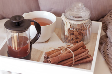 Home decor. French press with hot tea, cookies in glass jar, cup, knitted blanket. Warm winter. Cozy. 