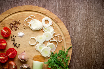 Fresh organic ingredients for salad making: spinach, tomatoes, sprouts, basil, olive oil on rustic background, top view.