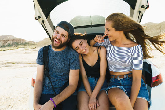 Friends sitting in car trunk
