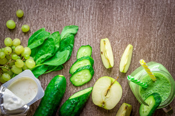 Green smoothie with apples, yogurt, spinach, cucumber on wooden background