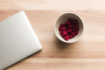 laptop and bowl with raspberries