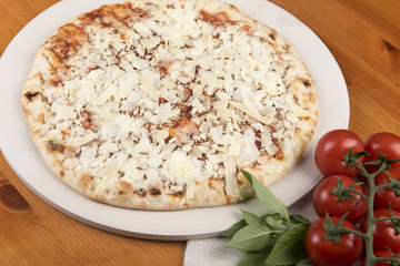 Margarita pizza with tomato and basil at the side 