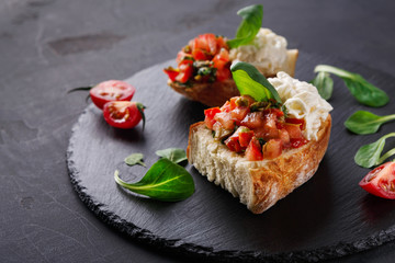 Bruschetta with cheese and vegetables on black background