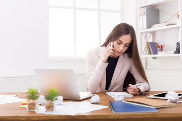 Serious business woman at work talking on phone
