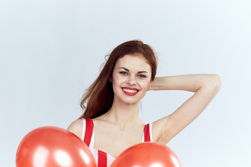 Beautiful young woman on a white background holds balloons, portrait
