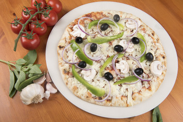 Uncooked vegetarian pizza with olives, peppers, onion, mushrooms and basil 