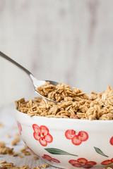 Almond Granola Breakfast Cereal In Bowl With Spoon