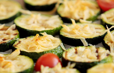 Grilled slices of zucchini with parmesan cheese and cherry tomatoes. Close up view.