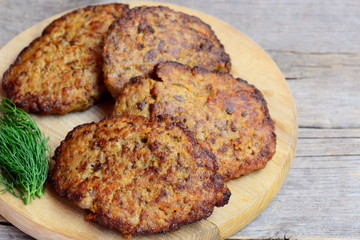 Chicken liver cutlets with vegetables. Home fried chicken liver cutlets on a wooden board. Chicken liver nutrition. Vintage wooden background. Rustic style. Closeup
