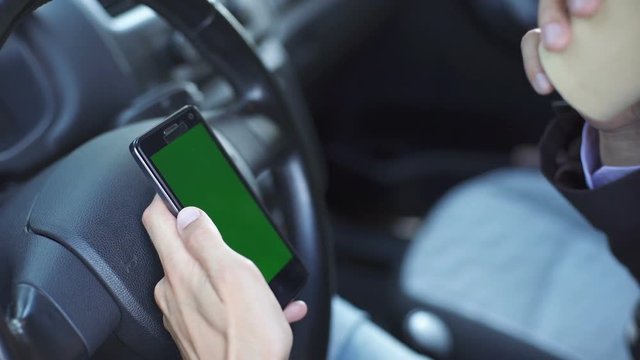 businessman having a coffee in car and used phone with green screen