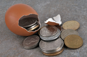 Pièces de monnaie sortant d'une coquille d'œuf 