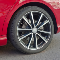 Obraz premium the wheel of the red car close-up