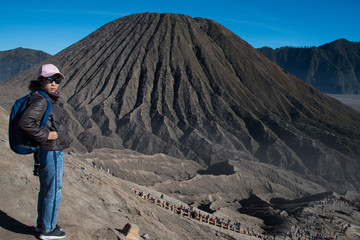 Fototapeta premium Woman tourism at top of crater view point at Mount Bromo volcano, view behind is Mount Batok JAVA, INDONESIA. 