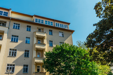 yellow house with penthouse in the roof and green tree