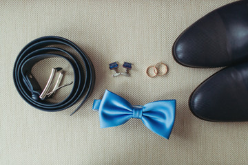elegant stylish dark male accessories on texture background. Top view of bloue bow-tie, shoes, wedding rings