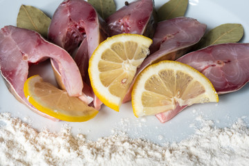 Fillet of fresh fish carp on a plate with spices and flour.