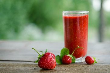  strawberries and strawberry cocktail smoothie on a wooden table