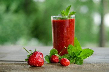  mint leaves, strawberries and strawberry cocktail smoothie on a wooden table