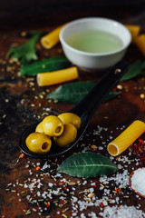 Olives in black spoon surrounded by other ingredients