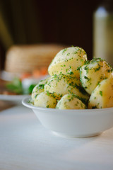 Young potatioes boiled with the herbs at restaurant table.