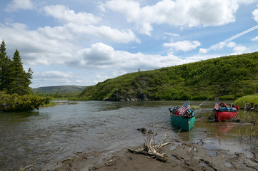 Beached canoes on scenic Alaskan river bank