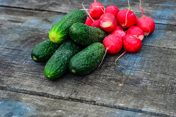 Radish and cucumbers on wooden table