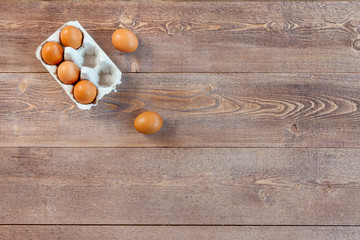 Raw eggs on wooden table, top view, free space