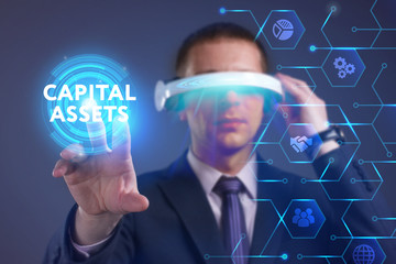 Business, Technology, Internet and network concept. Young businessman working on a virtual screen of the future and sees the inscription: Capital assets