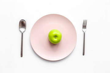 Slimming diet. Apple at plate on white background top view