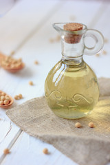 Obraz na płótnie Canvas Soy bean oil in glass bottle with soybeans around it.