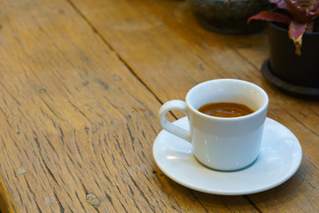 espresso coffee in white cup on old wooden table with copy space.