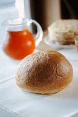 Fresh hot bread on white tablecloth at restaurant table.