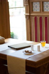 Restaurant table with menu book, tablecloth and salt shakers.
